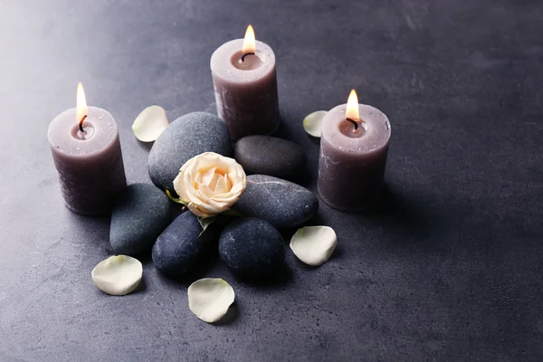 Uvolnit koncept - složení aroma svíčky s oblázky a květin na šedém pozadí — Stock fotografie