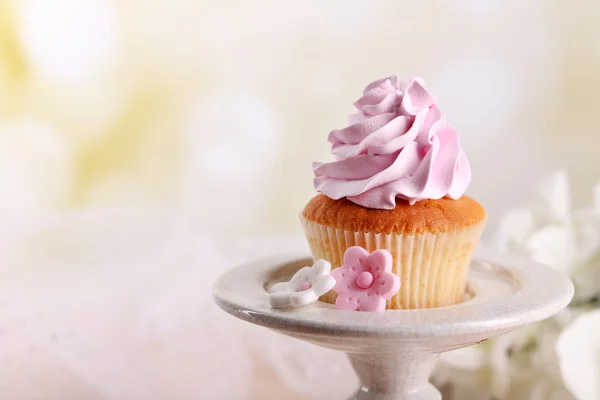 Leckere Cupcake am Stand, auf hellem Hintergrund — Stockfoto