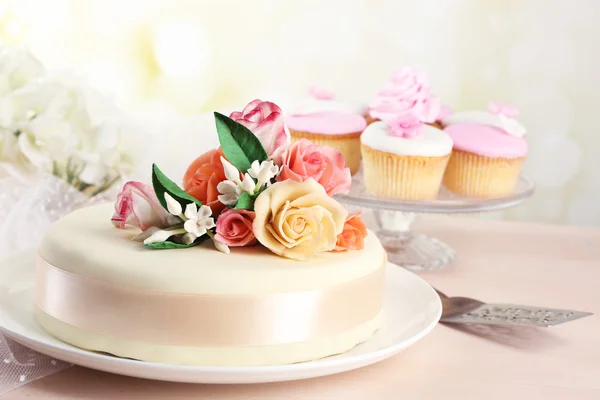 Cake met suiker bloemen, plakken op lichte achtergrond — Stockfoto