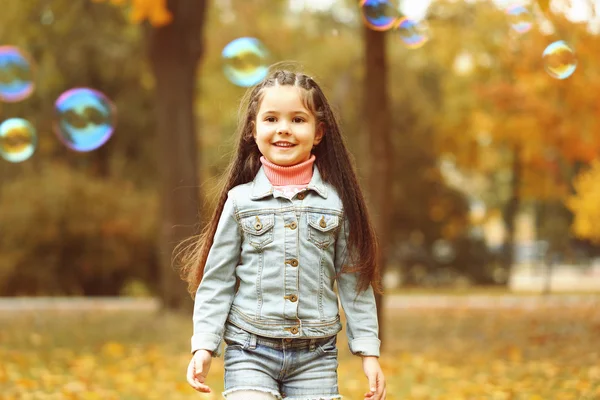 Linda chica jugando con burbujas de jabón en el parque —  Fotos de Stock