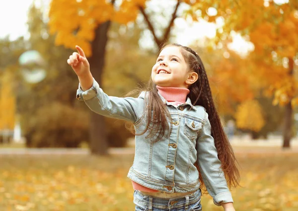 Leuk meisje spelen met zeepbellen in park — Stockfoto
