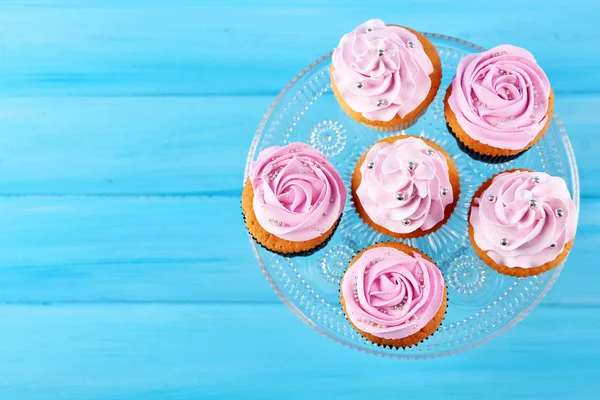 Cupcakes saborosos na cor de fundo de madeira — Fotografia de Stock