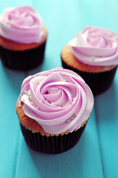 Smakelijke cupcakes op een houten achtergrond kleur — Stockfoto