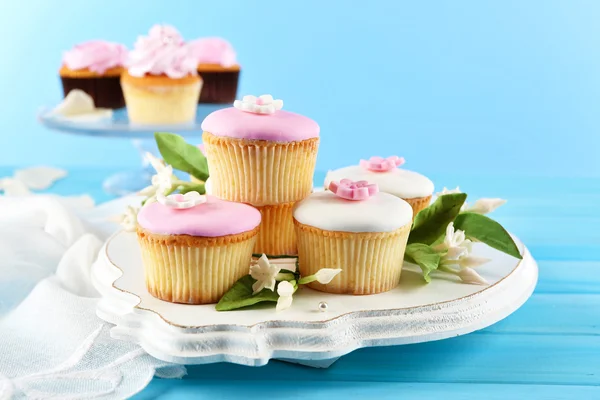 Tasty cupcakes on color wooden background — Stock Photo, Image