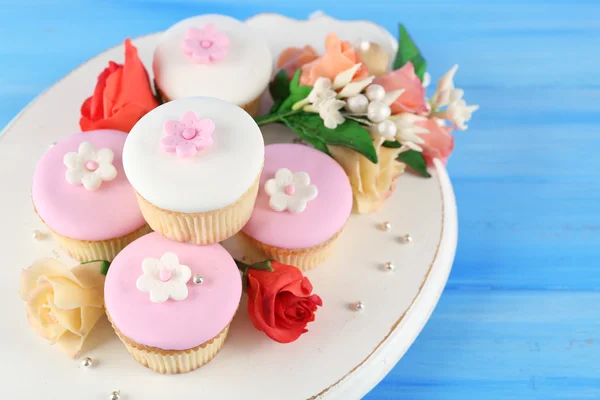 Leckere Cupcakes auf farbigem Holzhintergrund — Stockfoto