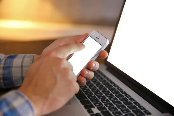 Joven usando su teléfono y portátil, de cerca — Foto de Stock