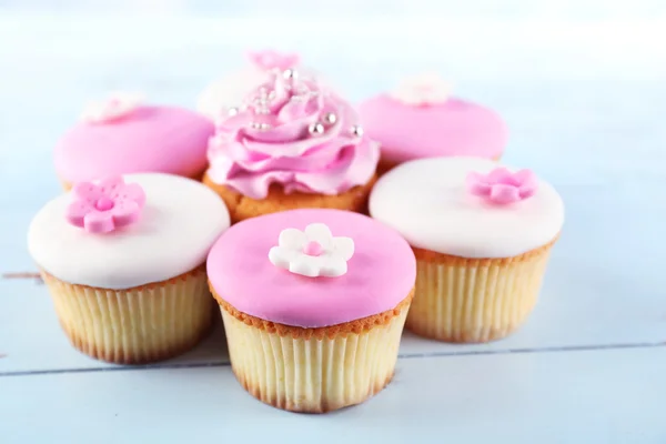 Leckere Cupcakes auf farbigem Holzhintergrund — Stockfoto
