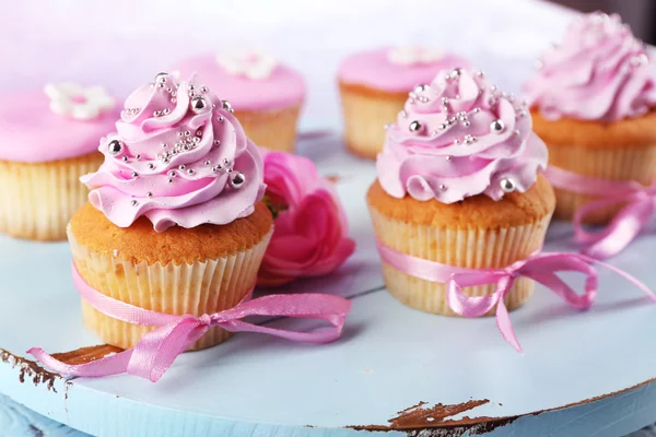 Smakelijke cupcakes op dienblad, op lichte achtergrond — Stockfoto