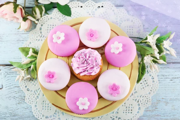 Вкусные кексы на тарелке, на цветном деревянном фоне — стоковое фото