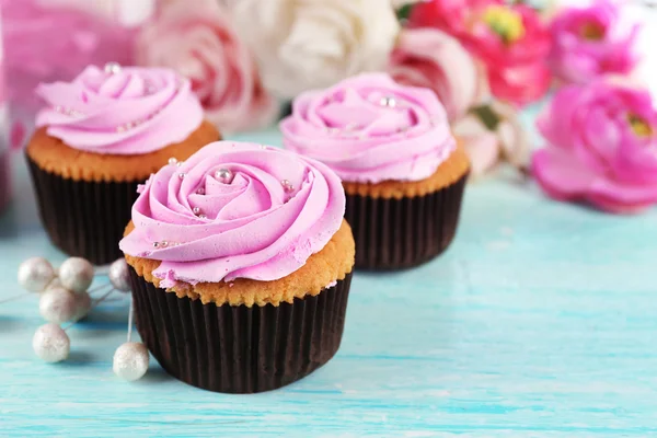 Leckere Cupcakes und Tasse Tee auf hellem Hintergrund — Stockfoto