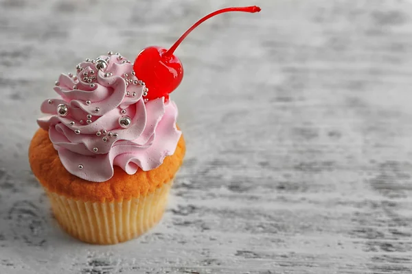 Smakelijke cupcake op een houten achtergrond kleur — Stockfoto