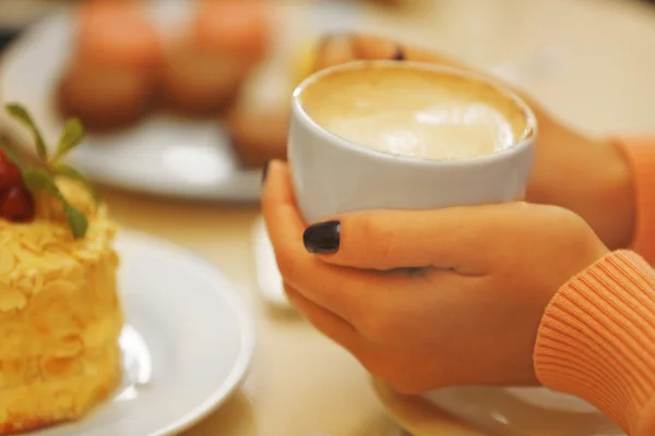 Donna che tiene una tazza di caffè nel caffè, primo piano — Foto Stock