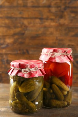 Ahşap arka plan üzerinde turşu sebzeli kavanoz