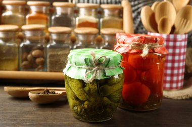 Kavanoz turşu sebze ve fasulye, baharatlar ve ahşap arka plan üzerinde mutfak eşyaları