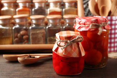 Kavanoz turşu sebze ve fasulye, baharatlar ve ahşap arka plan üzerinde mutfak eşyaları