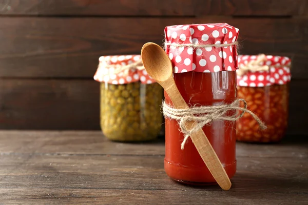 Pot en verre de sauce tomate piquante, sur fond en bois — Photo