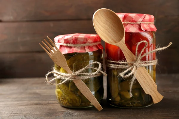 Potten met ingemaakte groenten op houten achtergrond — Stockfoto