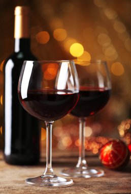 Kırmızı şarap ve altın arka plan üzerinde ahşap masa Noel süsler