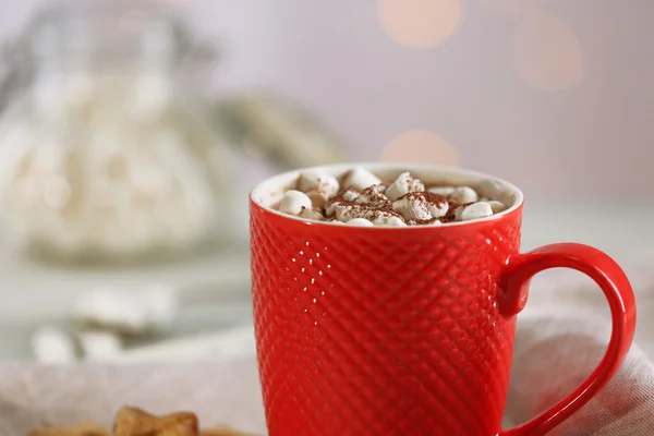 Uma xícara de cacau saboroso e marshmallow no fundo borrado — Fotografia de Stock