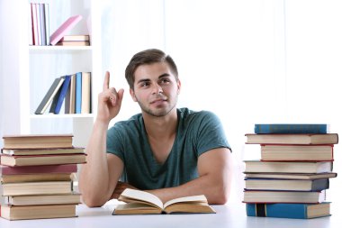 Genç adam masada kitap okumak