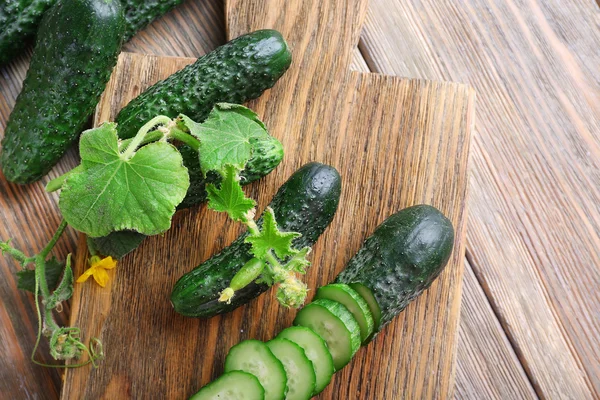 Sliced cucumbers and kitchen board — Stock Photo, Image