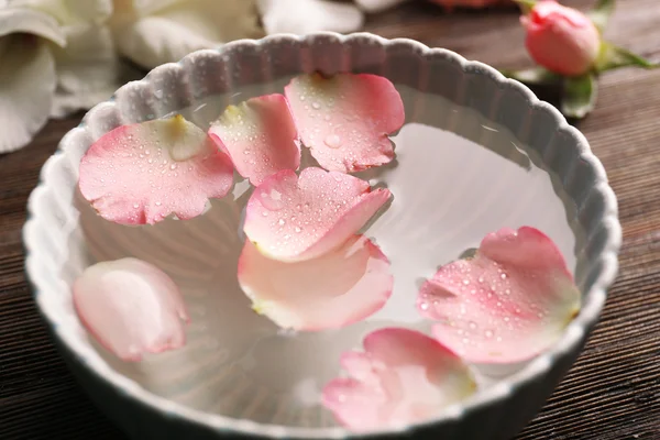 Pétalos rosados tiernos en un tazón de agua — Foto de Stock