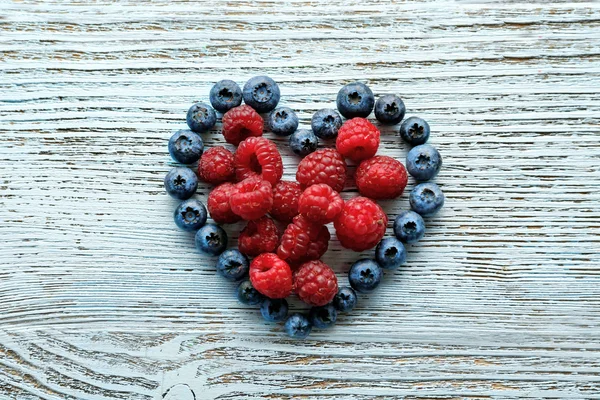 Heart shaped raspberries and blueberries — Stock Photo, Image