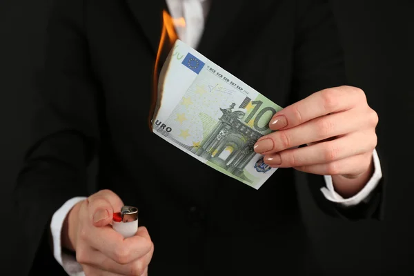 Woman burning Euro banknotes Stock Photo