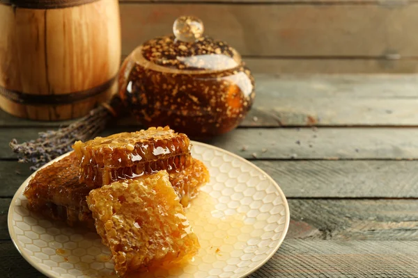 Honungskakor på plattan, potten med honung — Stockfoto