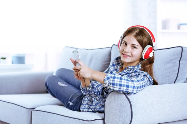 Красивая девушка слушает музыку на диване — стоковое фото