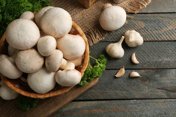 Cogumelos em cesta na superfície de madeira — Fotografia de Stock