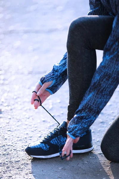 Mujer en ropa deportiva atando cordones en sn —  Fotos de Stock