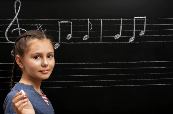 Chica escribiendo notas musicales — Foto de Stock
