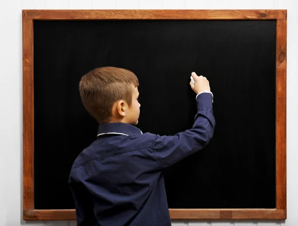 Jongen die zich voordeed op blackboard — Stockfoto