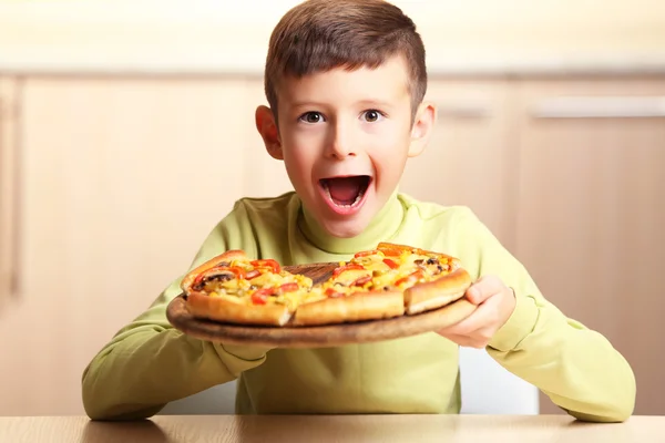 Lilla pojken äta pizza — Stockfoto