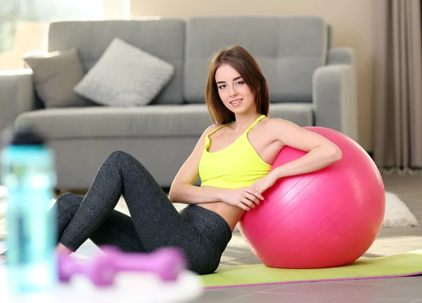 Flicka med fit boll hemma — Stockfoto