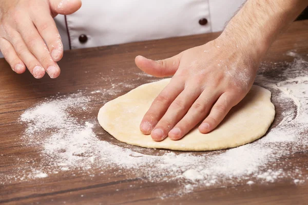 Hands preparing dough basis for pizza — Stock Photo, Image