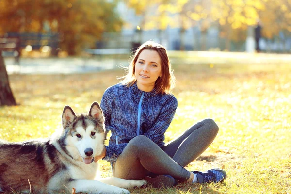 Kobieta siedząca z psem w parku — Zdjęcie stockowe