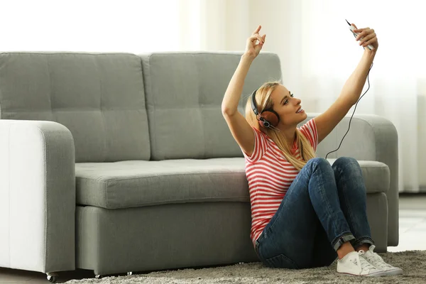 Woman sitting and listening to music — Stock Photo, Image