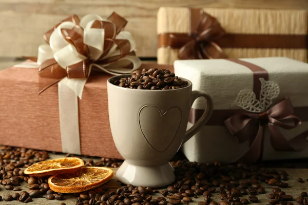 Regalos y granos de café en taza — Foto de Stock