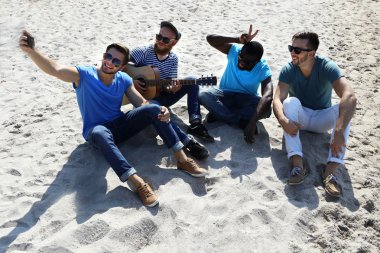 kum üzerine oturan adam