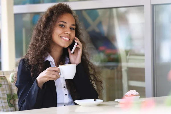 Woman speaking by cellphone and drinking coffee — Stock Photo, Image