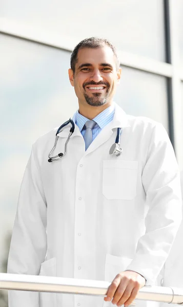 英俊的微笑的医生站在一排附近的诊所 — 图库照片