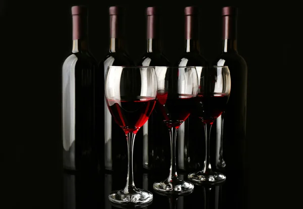 Wine glasses against bottles — Stock Photo, Image