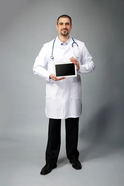 Retrato de um médico com comprimido nas mãos — Fotografia de Stock