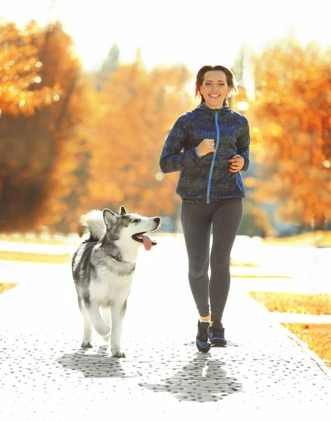 Mulher correndo com seu cão no parque — Fotografia de Stock