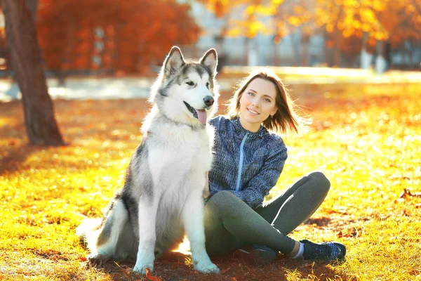 Donna seduta con il suo cane nel parco — Foto Stock