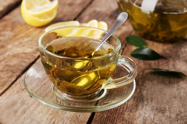 Glass cup of tea and teapot — Stock Photo, Image