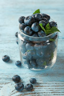 Ahşap masa üzerinde kavanoza taze yaban mersini yakın çekim