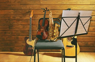 Müzik aletleri üzerinde ahşap arka plan karşı bir sandalye ve Not tutucu